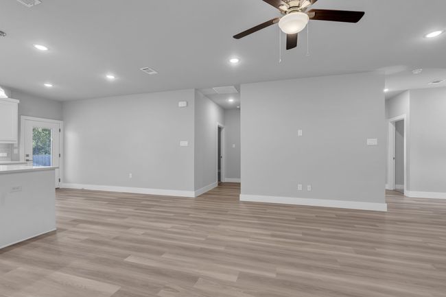 Unfurnished living room featuring a ceiling fan, recessed lighting, baseboards, and light wood-type flooring | Image 8