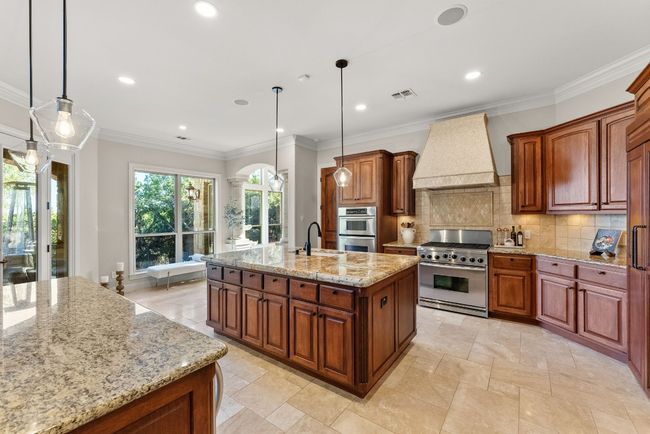Spacious kitchen with granite countertops, stainless steel appliances, plenty of countertop and cabinet space, a built in fridge and coffee bar. | Image 10