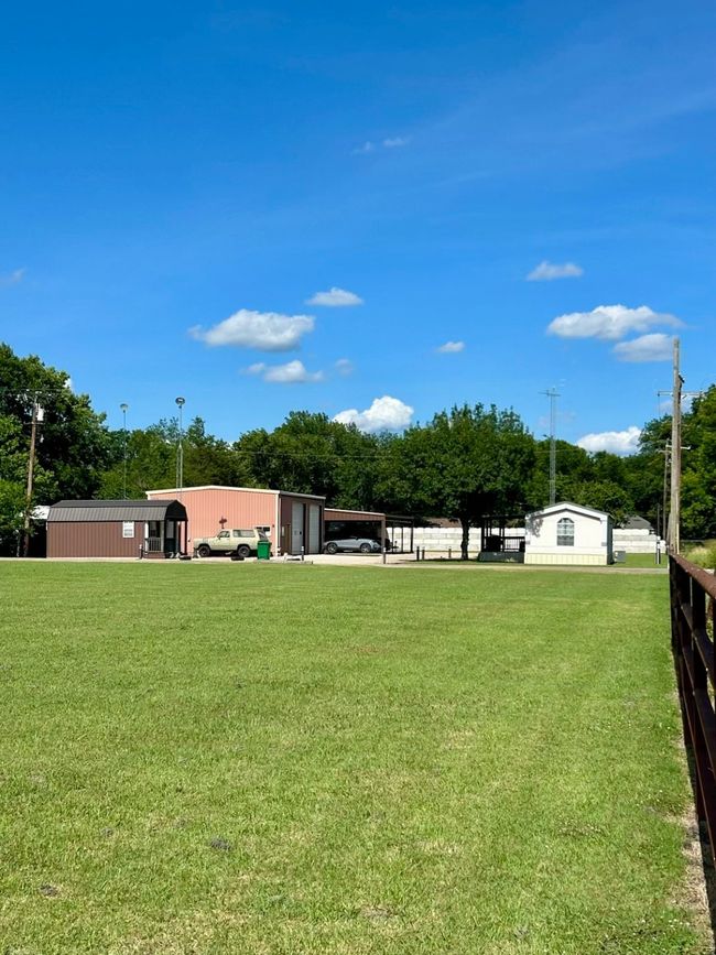 View of grassy yard featuring an outdoor structure and a pole building | Image 29