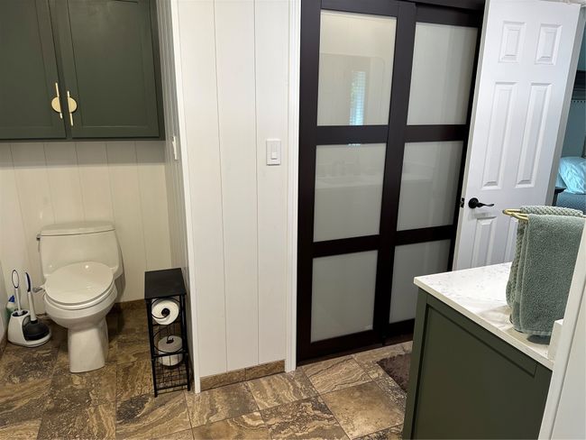 Bathroom with toilet, stone finish flooring, and vanity | Image 19