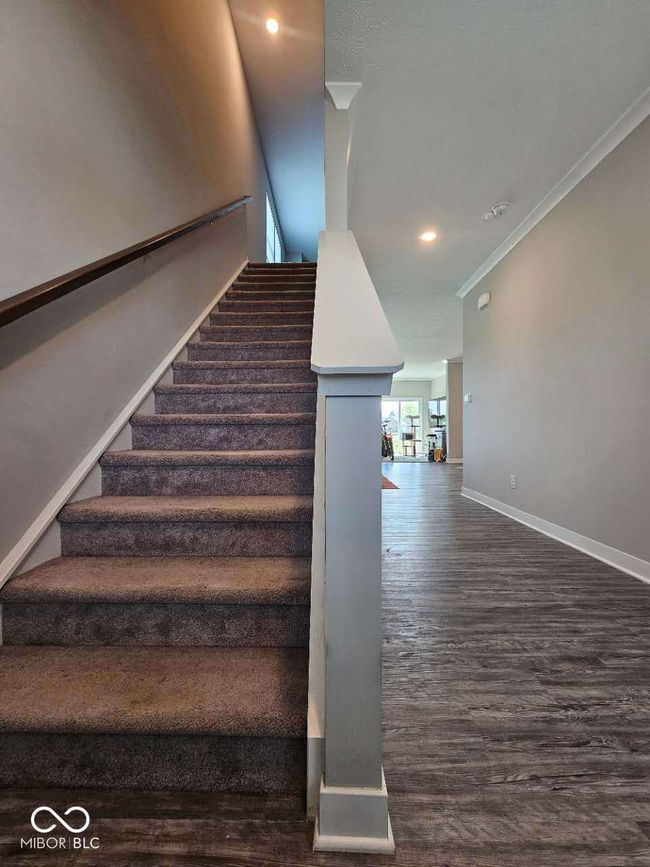 stairs with baseboards, wood finished floors, crown molding, and recessed lighting | Image 23