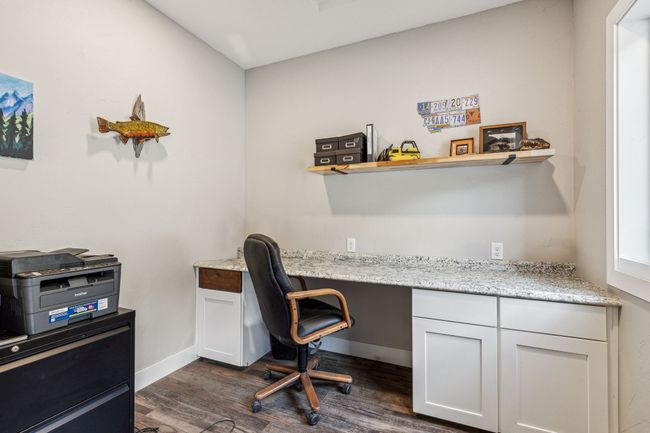 Office space with dark wood-style flooring, built in desk, and baseboards | Image 30