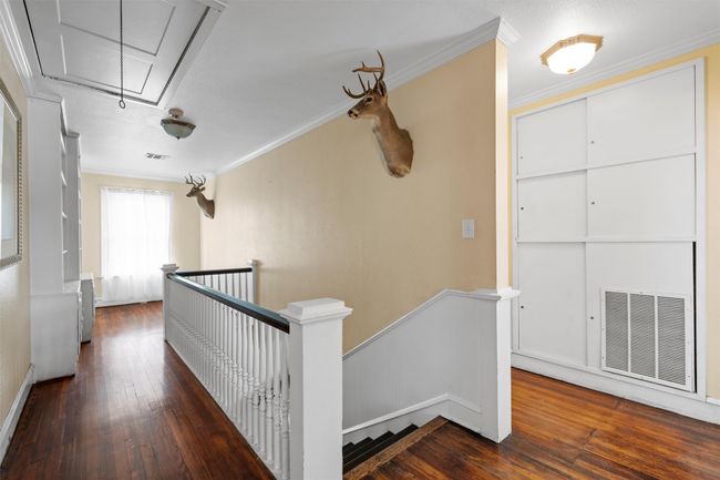 Hall with attic access, ornamental molding, an upstairs landing, and dark wood-type flooring | Image 19