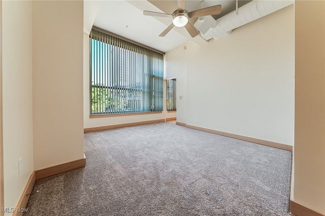 Carpeted bedroom with walk-in closet and ceiling fan. | Image 27