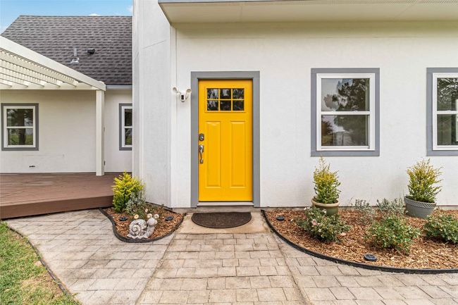 Property entrance with roof with shingles, stucco siding, and a deck | Image 7