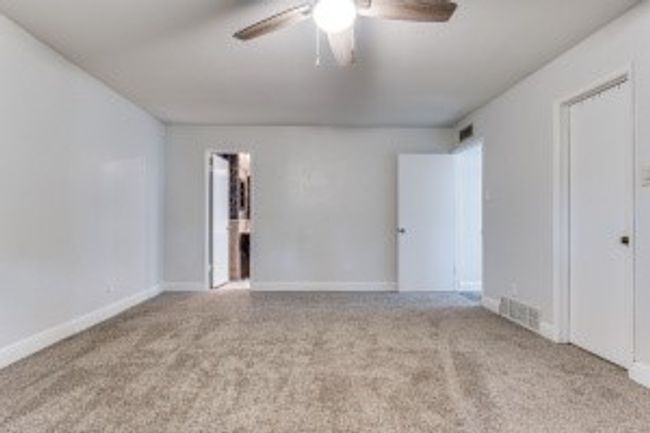 Carpeted empty room with baseboards, a ceiling fan, and visible vents | Image 20