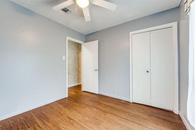 Unfurnished bedroom with baseboards, wood finished floors, a closet, and ceiling fan | Image 11