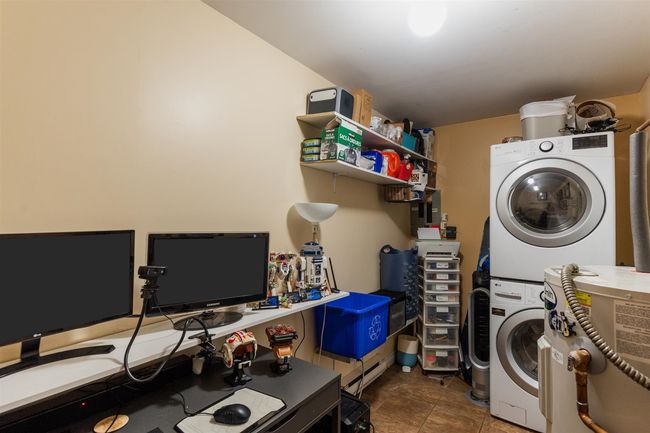 Washroom with estacked washer and dryer and tile patterned floors | Image 12
