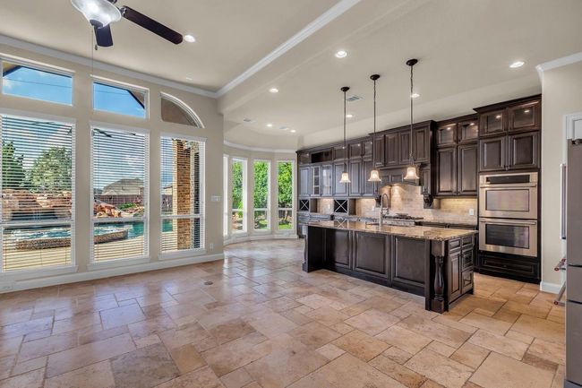 This open-concept living area seamlessly flows into the adjoining kitchen, creating a spacious and airy environment perfect for entertaining and everyday living | Image 7