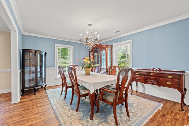 Dining area with a chandelier, crown molding, and wood finished floors | Image 7