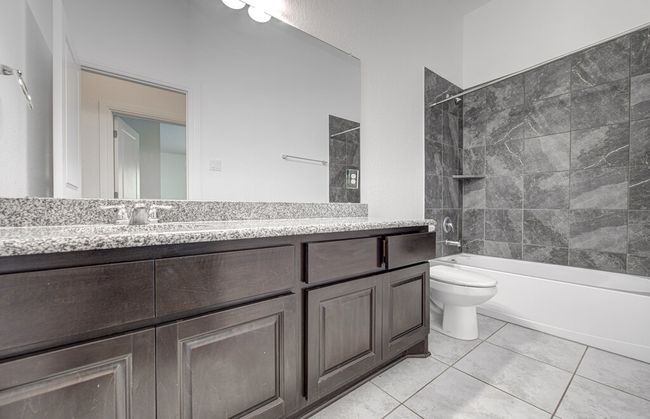 Bathroom featuring toilet, vanity, washtub / shower combination, and tile patterned flooring | Image 19