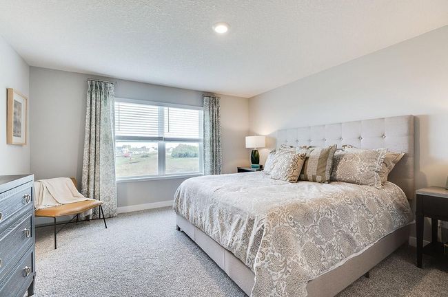 Spacious and modern would best describe this primary suite. This suite includes private access to an ensuite bath and walk-in closet. *Pictures are of a model home, actual colors and finishes may vary. | Image 21