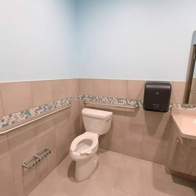 Half bathroom featuring vanity, toilet, tile walls, and a wainscoted wall | Image 11