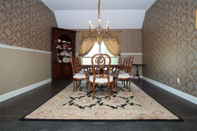 Dining room featuring a chandelier, wood finished floors, wallpapered walls, wainscoting, and baseboards | Image 14
