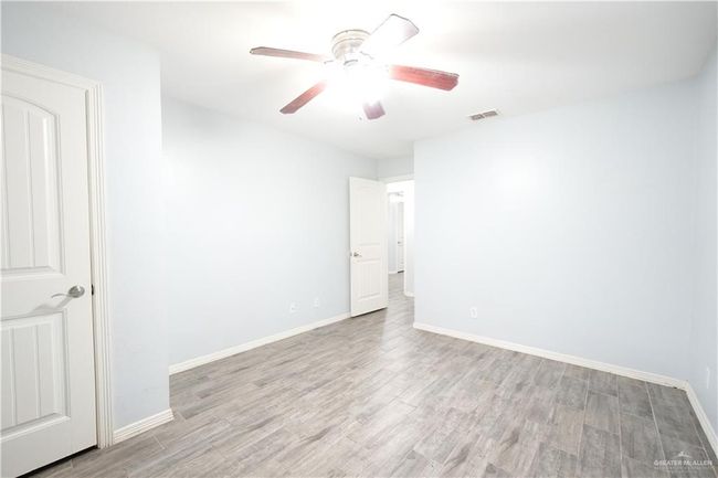 Unfurnished room featuring light wood-type flooring and ceiling fan | Image 15
