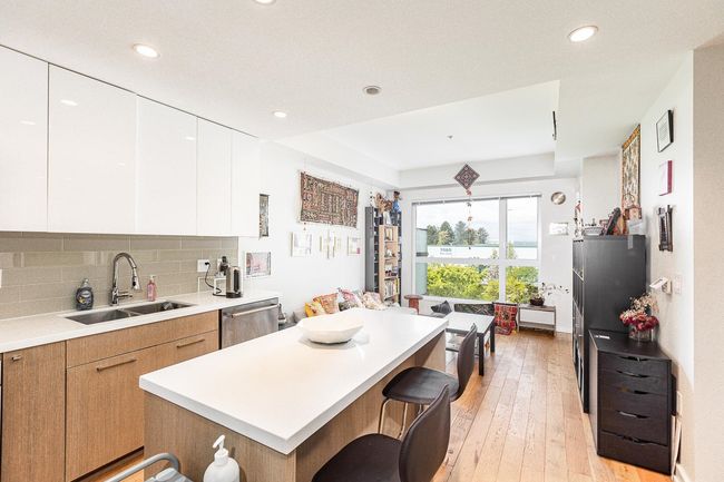 Kitchen with a sink, a center island, dishwasher, light countertops, and recessed lighting | Image 6