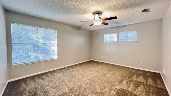 Unfurnished room featuring a ceiling fan, carpet floors, baseboards, and a textured ceiling | Image 7