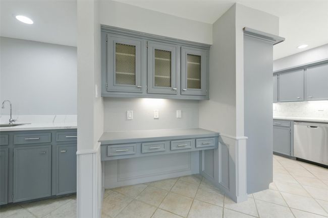 Built in desk with over head cabinets. Glimpse of the wet bar to the left. | Image 10