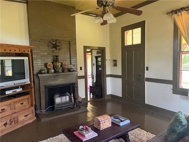 First floor living area featuring fireplace, wood flooring | Image 18