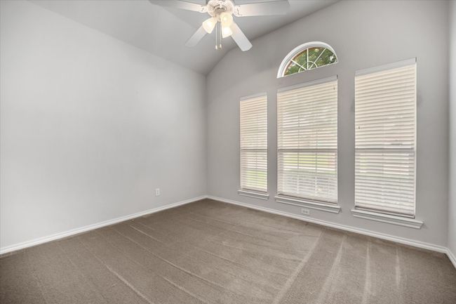 Spare room with lofted ceiling, a ceiling fan, and carpet flooring | Image 17