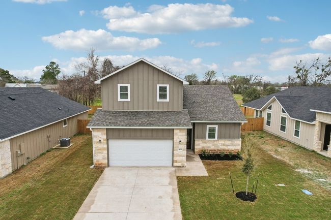 Traditional home featuring cooling unit, stone siding, board and batten siding, and a front yard | Image 39