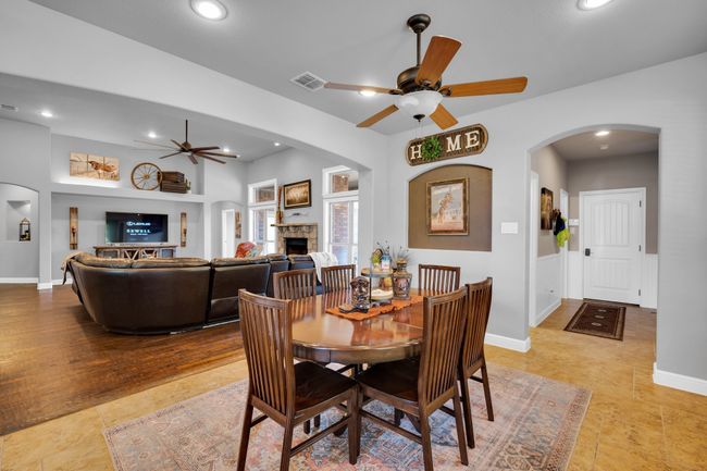 Tiled dining space featuring ceiling fan and a fireplace | Image 12