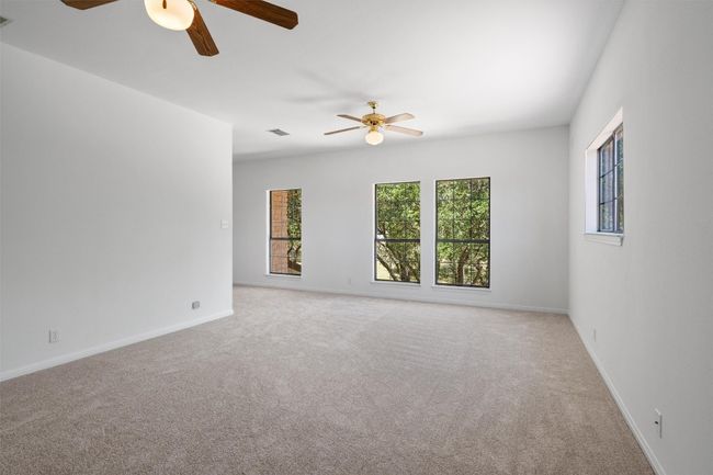 Carpeted spare room with ceiling fan, baseboards, and visible vents | Image 27