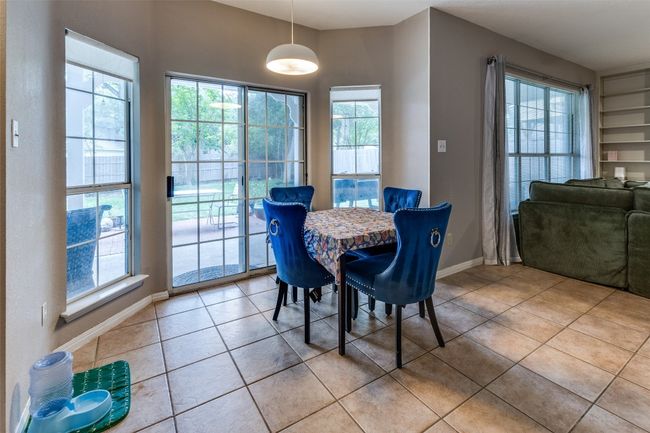 Kitchen, second dining open to additional living area with fireplace and built-in bookcases galore! | Image 11
