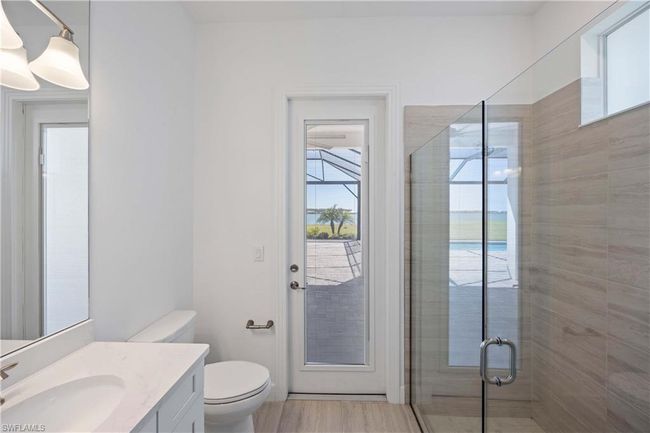 Bathroom featuring toilet, vanity, a stall shower, and wood finished floors | Image 22