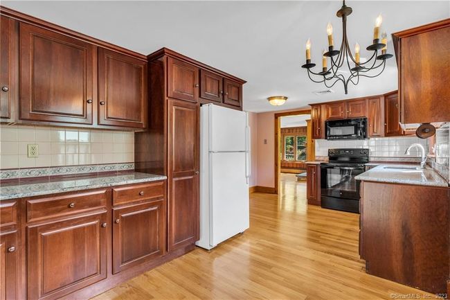 Located between the Family Room and Living Room the updated kitchen has hardwood floors. Notice the abundance of cabinetry and counter space. | Image 7