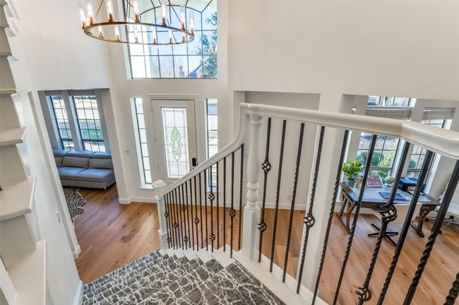 Entrance foyer with a high ceiling, a wealth of natural light, wood finished floors, and an inviting chandelier | Image 18