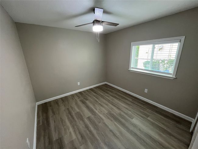 Spare room with baseboards, dark wood-type flooring, and ceiling fan | Image 14
