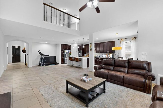 Kitchen with light stone countertops, decorative light fixtures, a breakfast bar, backsplash, and recessed lighting | Image 7