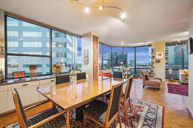 The dining room seamlessly flows into the living area, with continuous wood flooring creating a cohesive and elegant space. | Image 10