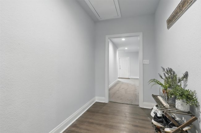 Corridor featuring dark wood-type flooring, attic access, recessed lighting, and baseboards | Image 33