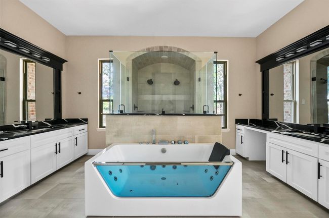 Full bath featuring a stall shower, baseboards, two vanities, and a tub with jets | Image 37