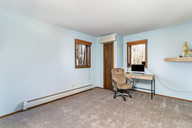 The second bedroom on the upper floor contains the 2nd mini-split air conditioner. There are also two closets and two windows overlooking the wooded lot. | Image 26