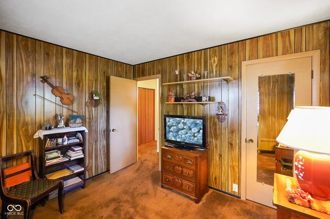 sitting room featuring carpet and wooden walls | Image 24