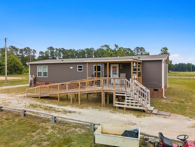 View of front of house with a front yard, a wooden deck, and crawl space | Image 38