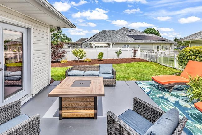 Fenced backyard with a patio area and outdoor lounge area | Image 13