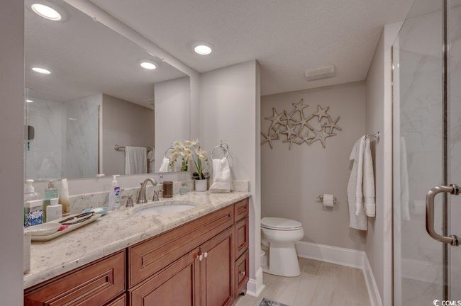 Bathroom with walk in shower, vanity, toilet, and a textured ceiling | Image 18