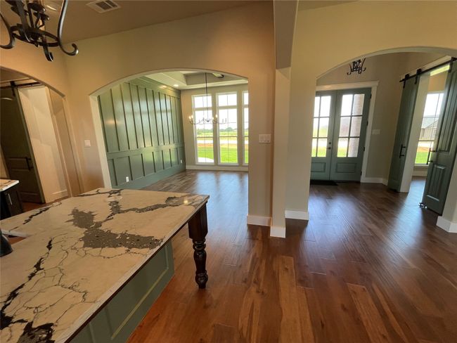 Kitchen with a chandelier, arched walkways, dark wood-style flooring, and plenty of natural light | Image 13