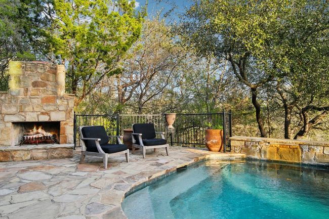 View of swimming pool with a patio and an outdoor stone fireplace | Image 35
