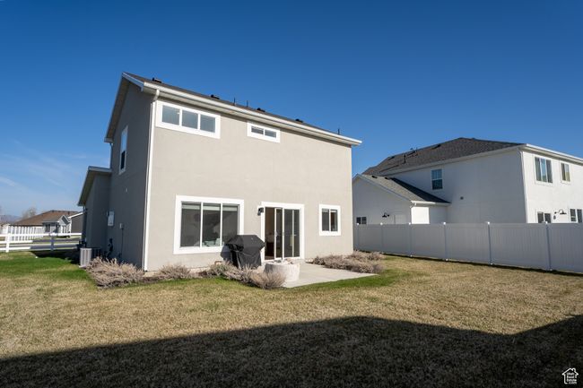 Rear view of house with stucco siding, fence, and a lawn | Image 22
