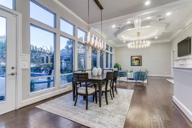 The heart of the living is the open kitchen, breakfast, family area of the home, with tasteful chandeliers, hardwood flooring and a wall of windows overlooking the mediterrean-style back yard. | Image 10