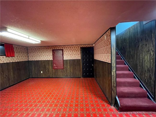 Finished basement with stairs, wallpapered walls, wainscoting, and wood walls | Image 29