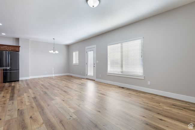 Unfurnished living room featuring a chandelier, light wood finished floors, and recessed lighting | Image 7