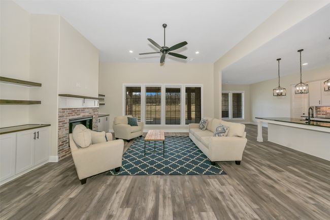 Living area featuring a ceiling fan, wood finished floors, recessed lighting, a fireplace, and baseboards | Image 18