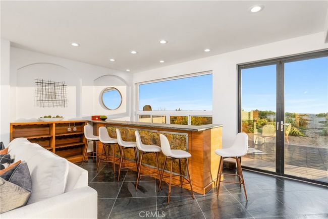 Large sitting bar with two wine/beverage fridges, an ice maker, and dishwasher & sink. | Image 17