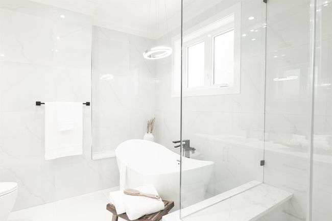 Full bathroom featuring tile walls, a freestanding bath, a marble finish shower, and toilet | Image 16